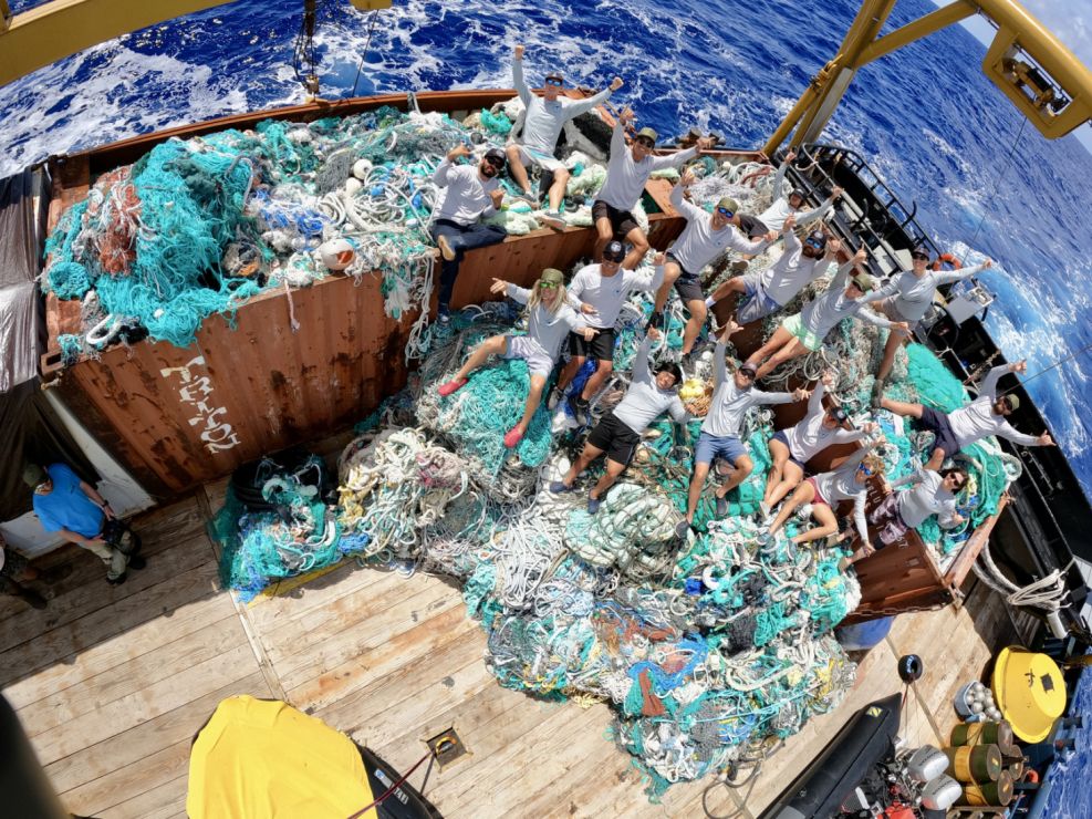 A marine debris removal team with recovered fishing nets and other waste